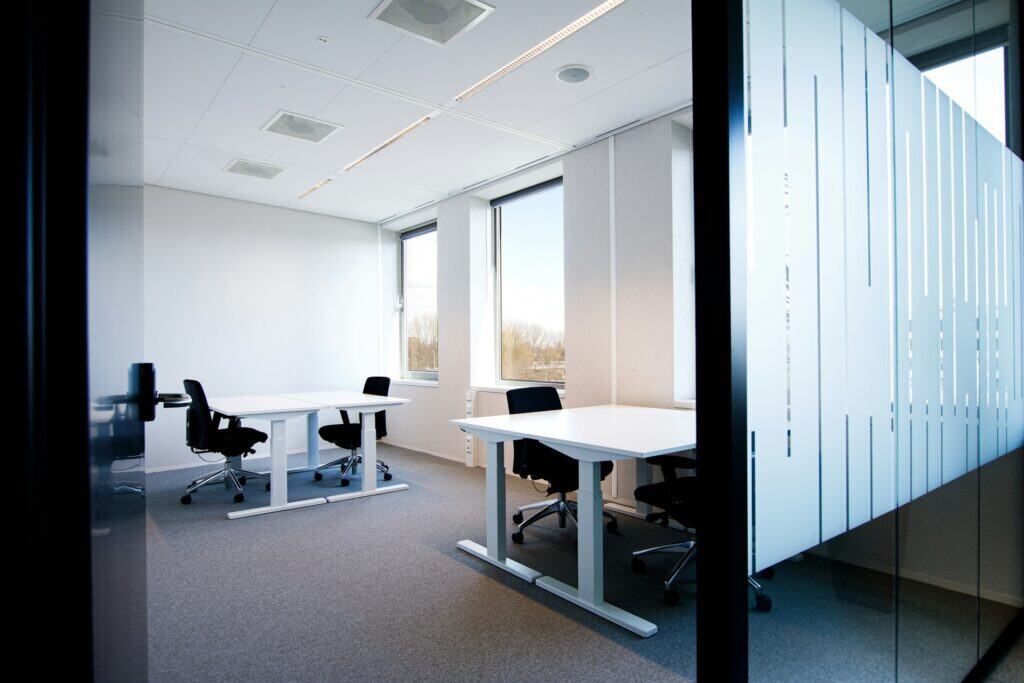 Minimalist office with height-adjustable desks – example of Cat A office fit out in UK workspace