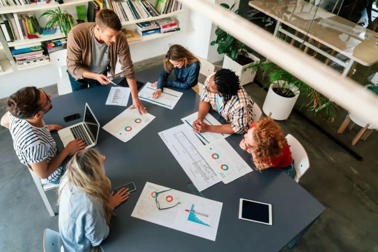 Collaborative office meeting with data charts – example of office design promoting employee engagement and retention