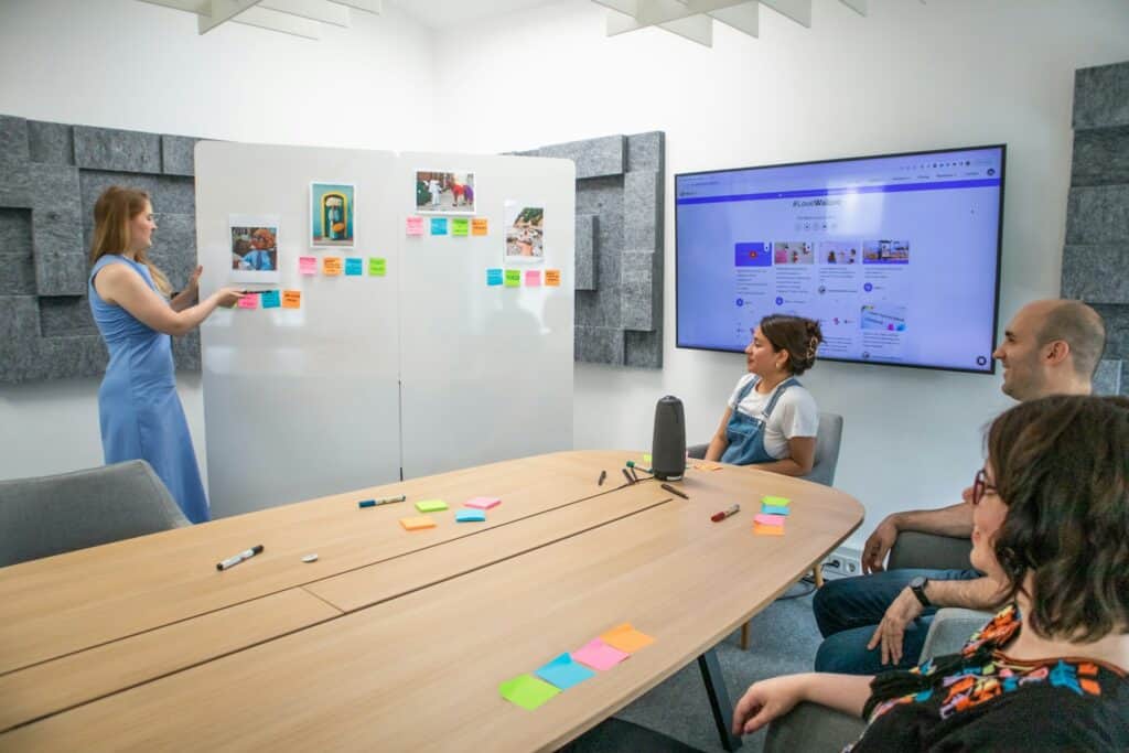 Team brainstorming in modern meeting room with acoustic design and visual boards – enhancing creativity and staff retention