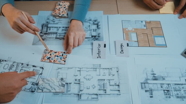 SME office refurbishment planning with architectural drawings and material samples for growing business workspace design