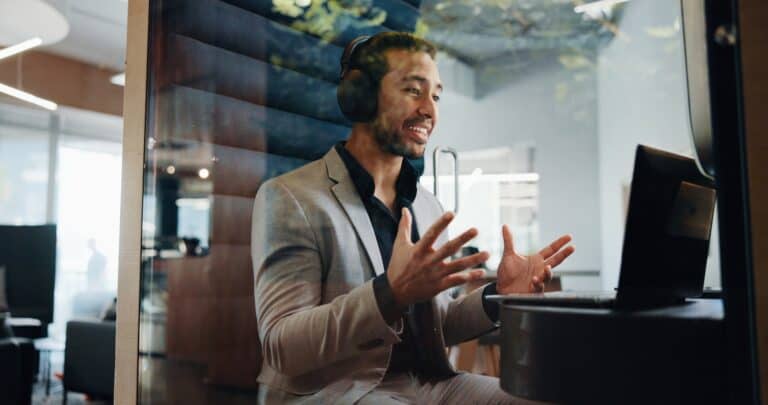 Professional using a video conferencing pod in a modern hybrid office, designed for private virtual meetings and enhanced acoustic performance