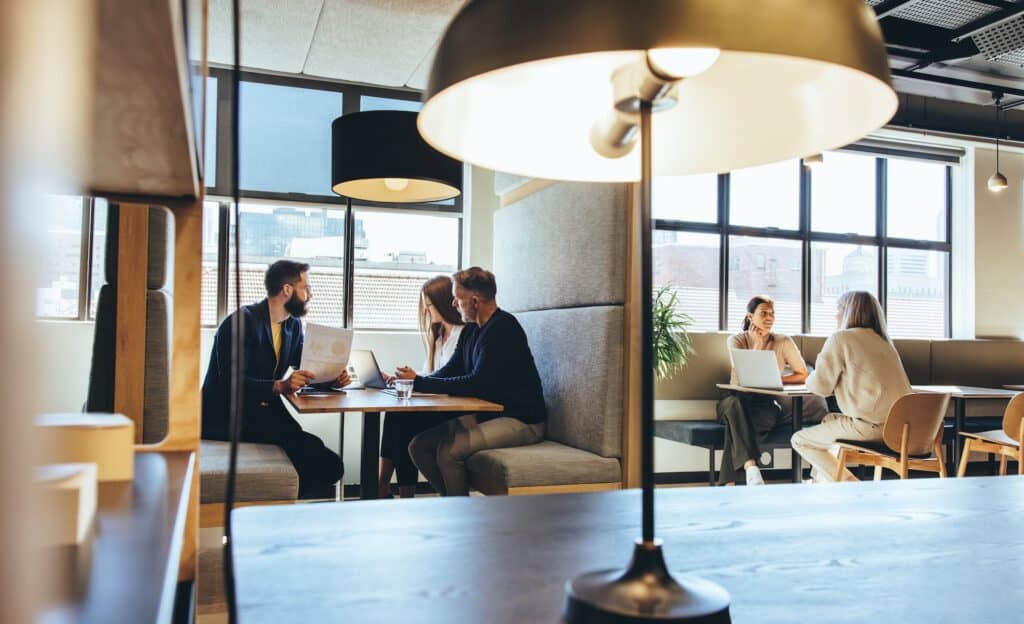Team collaboration in a flexible hybrid office space featuring booth seating and natural light - ideal for casual meetings and agile working
