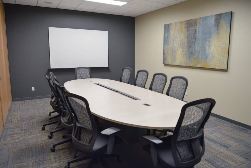Professional law firm conference room with oval table and presentation screen for client meetings and solicitor consultations