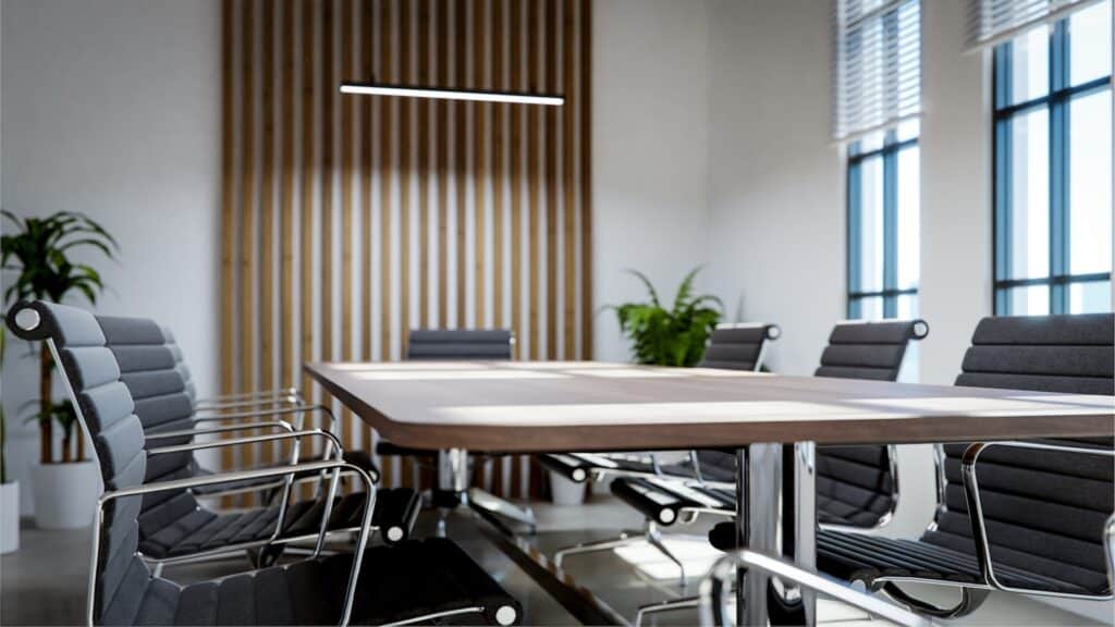 Small office meeting room with professional conference table, executive seating and acoustic wood partition demonstrating space-efficient design for client meetings